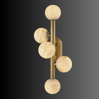 Brass alabaster wall sconce featuring five warm glowing alabaster spheres.