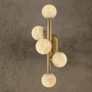 Luxury alabaster wall lamp with five carved alabaster globes on a vertical brass frame.