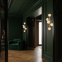 Alabaster Alba wall lights installed in a luxury hallway with green wall panels.