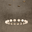 Luxury circular alabaster chandelier with 18 glowing spheres suspended from brass canopy.