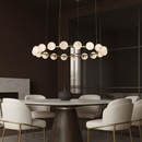 Galaxia alabaster chandelier illuminating a modern dining room with a round table.