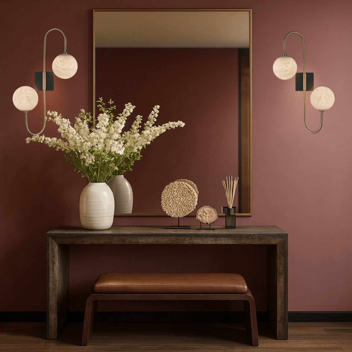 Pair of alabaster wall lamps illuminating a hallway above a console table