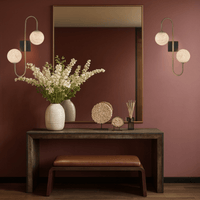 Pair of alabaster wall lamps illuminating a hallway above a console table