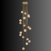 Multi-drop alabaster globe chandelier suspended from brass frame for double-height spaces