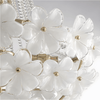 White Murano-style glass petals mounted on the gold frame of the chandelier.