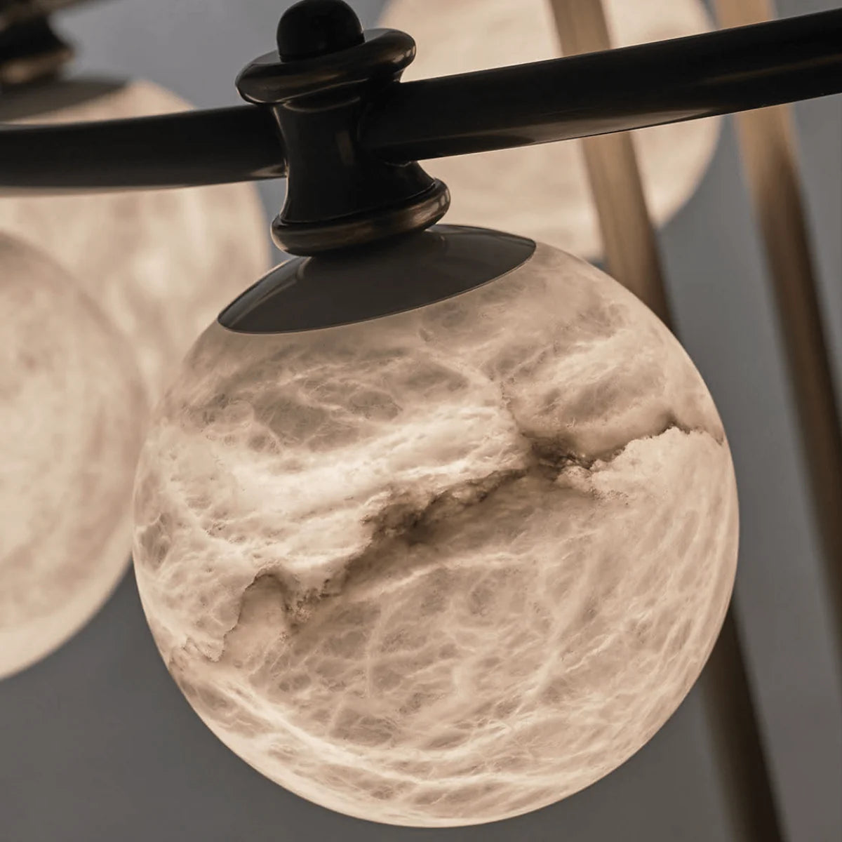 Close-up view of the Alabaster Aria chandelier by HDLS Lighting Ltd, highlighting the natural veining and translucent glow of genuine alabaster stone crafted into a polished spherical shade.