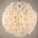 Close-up of Camellia Fiorita Globe chandelier with hand-blown white floral glass and warm light.