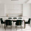 Halo Luxe Elara linear crystal chandelier installed in a modern white dining room with green velvet chairs.