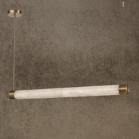 Linear alabaster pendant with brass caps suspended from ceiling, glowing softly in a modern luxury interior.