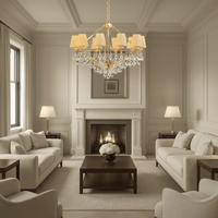 Elegant gold chandelier illuminating a refined beige living room with marble and soft lighting.