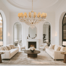 Luxurious living room with white sofas, a large Italian inspired designer chandelier by HDLS Lighting ltd and a fireplace.