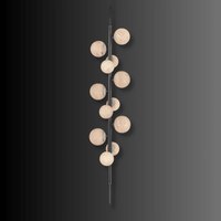 Modern vertical alabaster lighting with illuminated stone spheres on a copper frame.