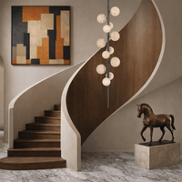 Vertical alabaster chandelier installed in modern double-height staircase interior.