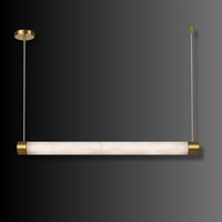 Alabaster Lumen linear pendant shown against a dark gradient background with brass-finished end caps.