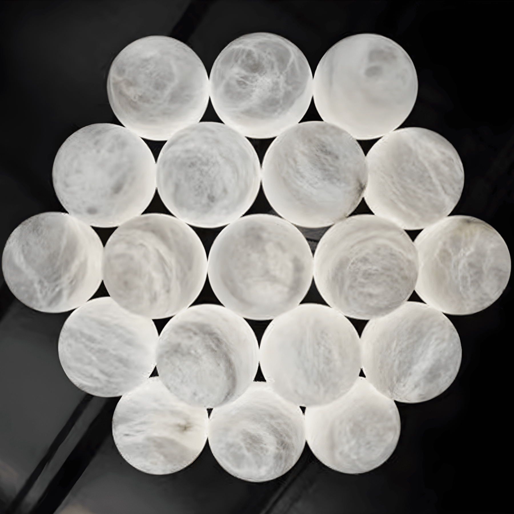 Close-up of illuminated Spanish natural alabaster spheres forming chandelier cluster.