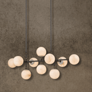 Linear Spanish alabaster chandelier with 10 stone spheres on solid copper bar, front view.