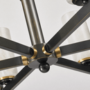 Close-up of solid copper hub with fixed radial arms forming the structural core of the chandelier.