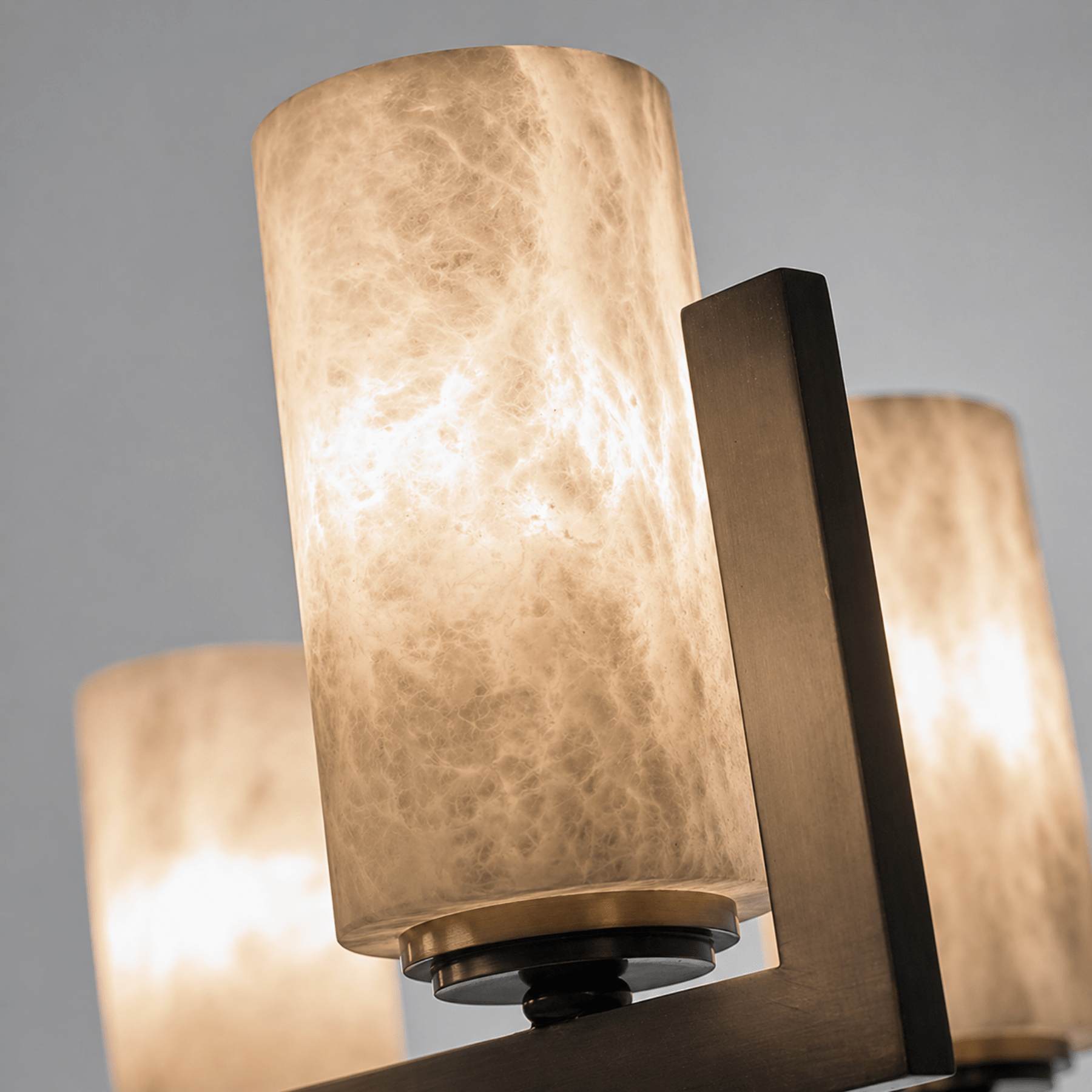 Close-up of illuminated Spanish alabaster cylinder showing natural veining and warm light diffusion.