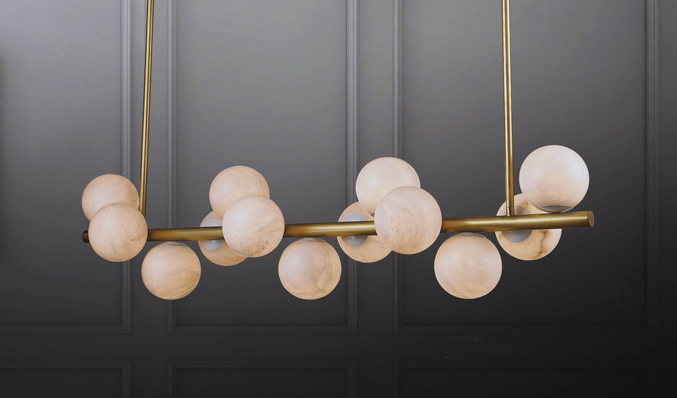Alabaster linear pendant installed above dining table with warm alabaster glow