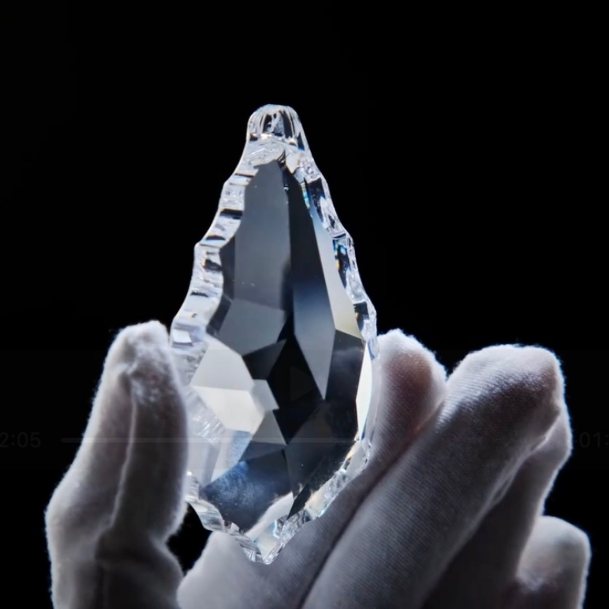 A gloved artisan holding a precision-cut Asfour crystal — symbolising HDLS Lighting’s dedication to craftsmanship, clarity, and French-inspired luxury.