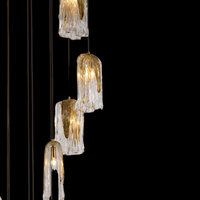 Close-up of Aurora Lava Murano-style hand-blown glass pendants showing golden glow, textured glass detail, and brass fittings