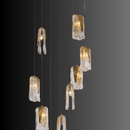 Aurora Lava cascading chandelier illuminated on dark background, featuring molten glass-inspired pendants and brass canopy.