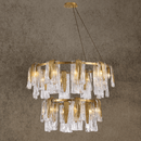 Luxury Aurora Maestra double-tier chandelier with brass frame and Murano-style glass against a neutral beige background.
