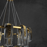 Close-up of Aurora Maestra chandelier showing textured Murano-style glass ribbons, polished brass hardware.