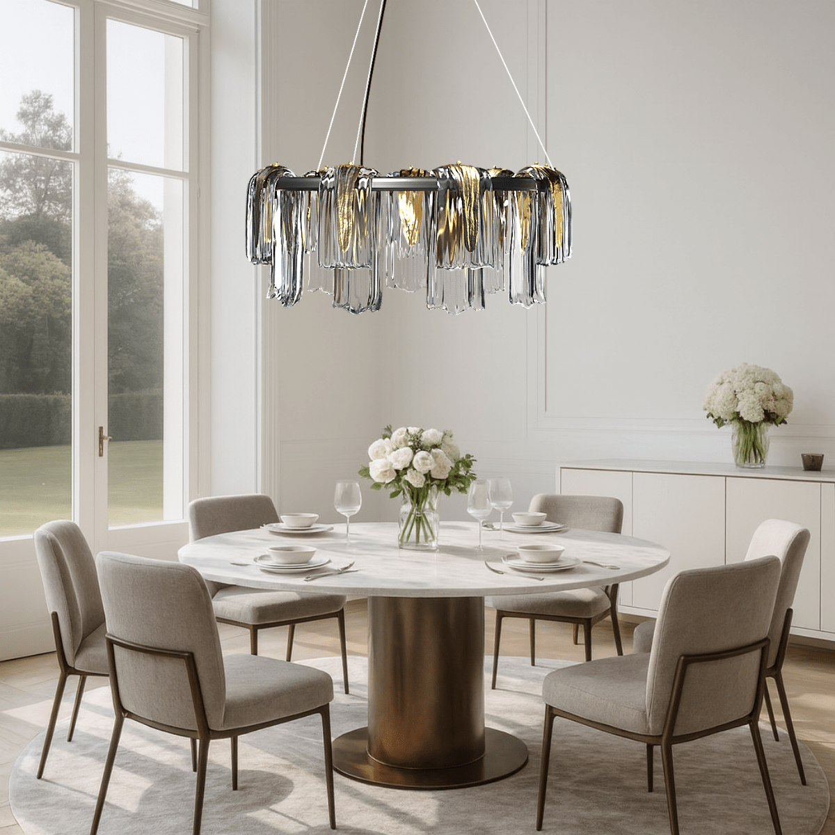 Aurora Sublime chandelier installed above a modern dining table, adding warm sculptural illumination to a luxury interior setting.