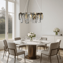 Aurora Sublime chandelier installed above a modern dining table, adding warm sculptural illumination to a luxury interior setting.