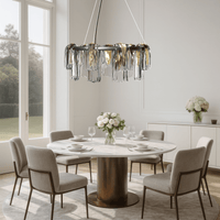 Aurora Sublime chandelier installed above a modern dining table, adding warm sculptural illumination to a luxury interior setting.