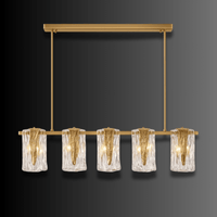 Aurora Vellum chandelier against dark background, showcasing brass frame and vellum-like Murano-style glass folds.