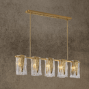 Luxury Aurora Vellum linear chandelier in brass with Murano-style folded glass shades, shown in a front studio view.