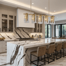 Aurora Vellum linear brass chandelier illuminating a luxury kitchen island, showcasing warm modern lighting.
