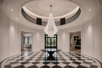 Bel Air monumental crystal chandelier installed in a two-story foyer with a circular gallery and checkerboard floor.