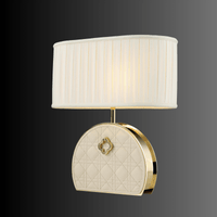 Front view of the Bellmont designer table lamp with quilted leather base, copper detailing, and pleated ivory fabric.
