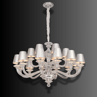 Front view of Cadogan crystal chandelier with tailored ivory shades and silver-toned structure