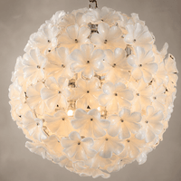 Close-up of Camellia Fiorita Globe chandelier with hand-blown white floral glass and warm light.