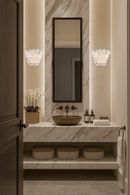 Murano-style floral wall sconces installed beside a bathroom mirror in a luxury interior.