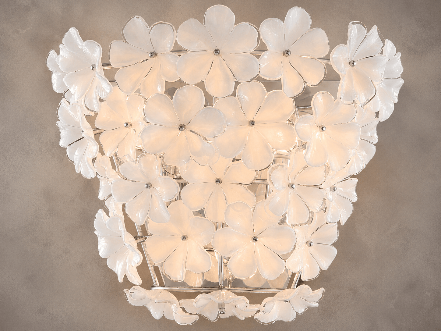 Close-up of Camellia Fiorita floral wall sconce with illuminated Murano-style glass petals