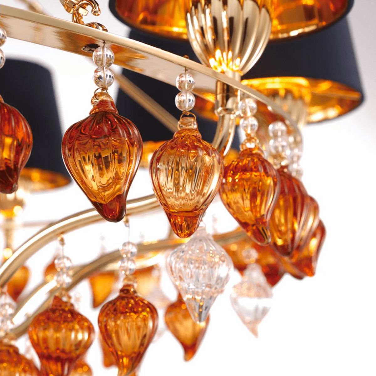 Macro shot of hand-blown Murano-style amber glass droplets and crystal accents from the Donatello Imperiale chandelier.
