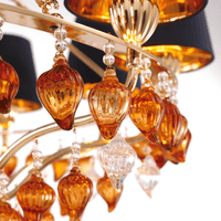 Macro shot of hand-blown Murano-style amber glass droplets and crystal accents from the Donatello Imperiale chandelier.