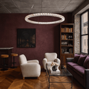 Halo Luxe Seraphina crystal chandelier installed in a modern living room with warm decor, showcasing halo illumination.