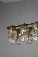 Aurora Magma linear chandelier with artisan glass panels suspended in a modern interior, showcasing sculptural lighting design.