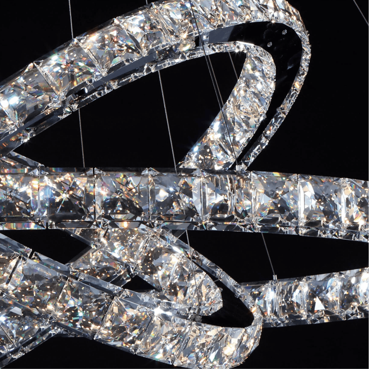 Close-up detail of the Halo Luxe Astraea chandelier showing precision-cut crystals and polished stainless steel rings.