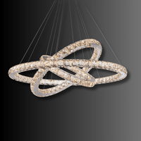 Modern three-ring Halo Luxe Astraea crystal chandelier shown on a dark background highlighting its reflective LED glow.