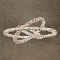 Luxury Halo Luxe Astraea chandelier with three interlocking crystal rings suspended on cables, glowing in warm LED light.