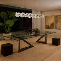 Modernus Linear chandelier illuminating a contemporary dining room with glass table and soft lighting.