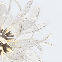 Close-up of Helios chandelier showing hand-forged Murano-style glass blades with warm internal illumination.