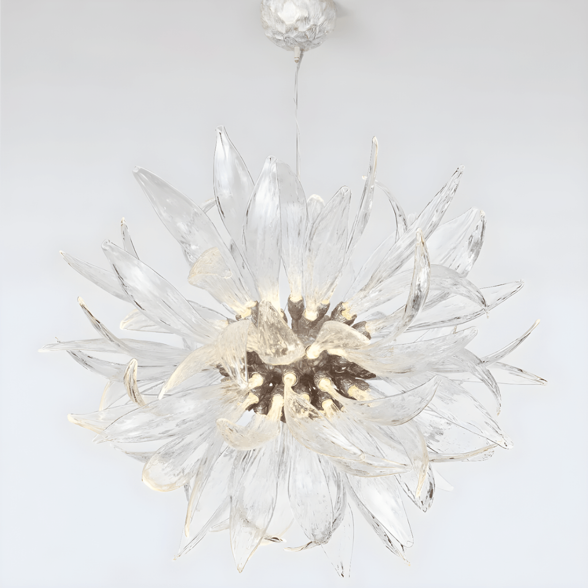 Helios sunburst chandelier displayed on a white background, highlighting sculptural glass blades and warm LED core.